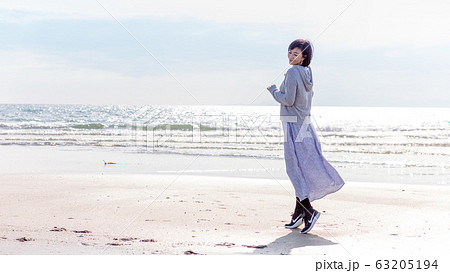 波打ち際 砂浜で遊ぶ健康なミドル女性  健康イメージ 63205194
