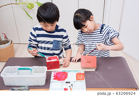 絵の具で作品に色を塗る小学生 63206924