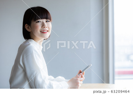 カフェでたたずむ女性 63209464