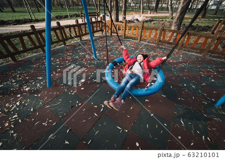 Happy child girl on swing. Little kid playing in the autumn pack. Happy child girl on swing. Little kid playing in the autumn pack. 63210101