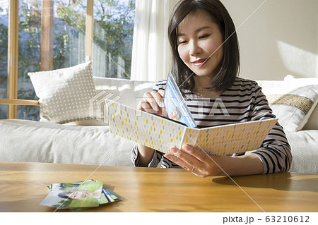 アルバムを眺める若い女性 63210612