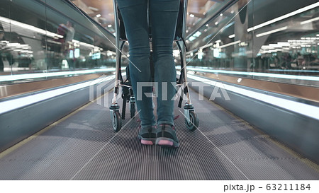 woman with luggage cart at airport terminal lobby 63211184