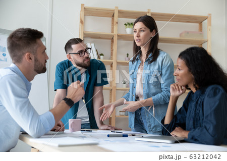 Focused young diverse employees listening to motivated skilled female professional. 63212042