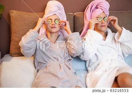 Two girlfriends with towels on their heads, doing spa treatments at home in bed Two girlfriends with towels on their heads, doing spa treatments at home in bed 63216553