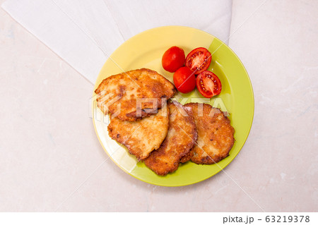 Potato pancakes with meat and tomatoes on green 63219378
