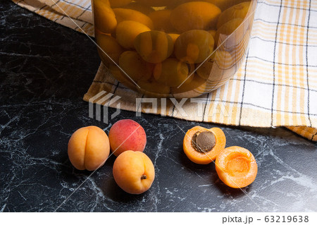 Juicy harvested apricots and big glass jar with Juicy harvested apricots and big glass jar with 63219638