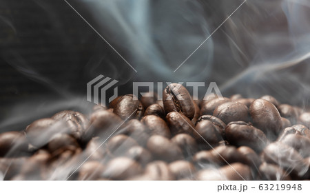 Aroma roasted coffee beans with smoke rising over Aroma roasted coffee beans with smoke rising over 63219948