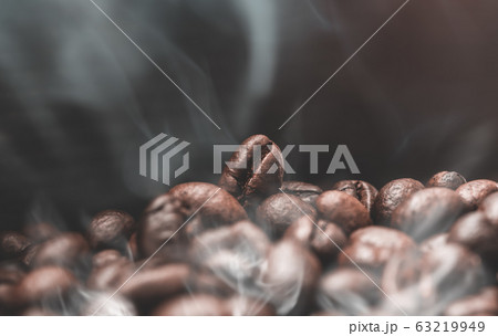 Aroma roasted coffee beans with smoke rising over Aroma roasted coffee beans with smoke rising over 63219949