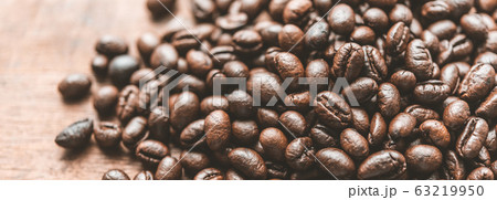 Roasted coffee beans on grunge wood table Roasted coffee beans on grunge wood table 63219950
