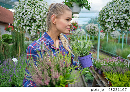 Female florist or gardener in flower shop or 63221167