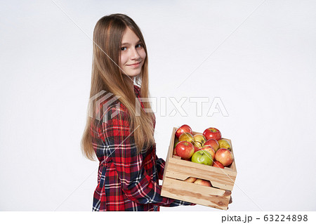Teen girl with apples and pears in a box Teen girl with apples and pears in a box 63224898