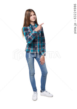 Teen girl in checkered shirt standing casually Teen girl in checkered shirt standing casually 63224986