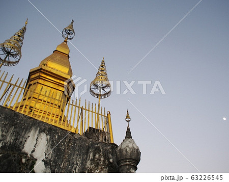 reflect sunlight at the buddhism golden stupa: PHU-SI or PHOUSI monument under twilight sky at evening time in LUANG PRABANG, LAOS reflect sunlight at the buddhism golden stupa: PHU-SI or PHOUSI monument under twilight sky at evening time in LUANG PRABANG, LAOS 63226545