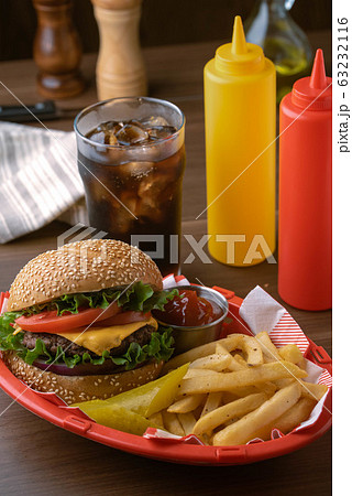 cheese burger and french fries in plastic basket 63232116