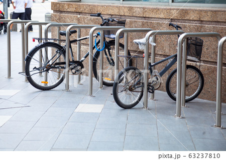 Bicycle top tubes are securely chained, by chain links and locks, to the metal bike racks 63237810