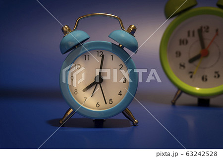 Twin bell analog alarm clocks over blue background 63242528