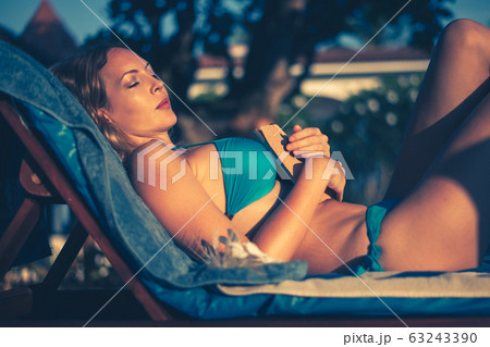 Beautiful young woman in bikini swimsuit sleeping Beautiful young woman in bikini swimsuit sleeping 63243390