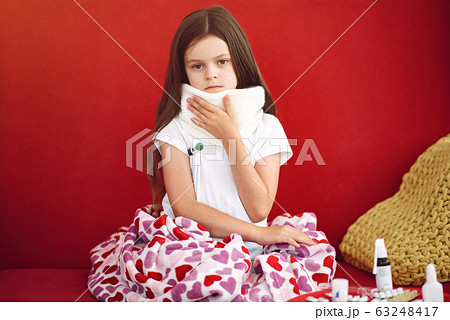 Little girl sitting at home with a cold 63248417