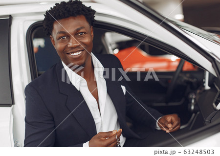 Handsome and elegant black man in a car salon 63248503