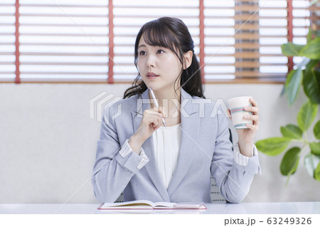 オフィスでコーヒーを飲むビジネスウーマン 63249326