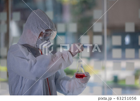 Male scientist testing experiment in a science lab where he holding scientific test tube full of chemical substance. The researcher is analyzing medicine related innovation. Microbiology concept. Male scientist testing experiment in a science lab where he holding scientific test tube full of chemical substance. The researcher is analyzing medicine related innovation. Microbiology concept. 63251056