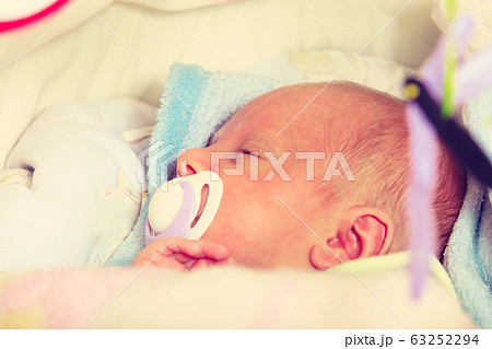 Closeup of little newborn sleeping with teat in Closeup of little newborn sleeping with teat in 63252294