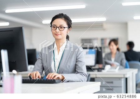 オフィスでタイピングするミドルエイジの女性 オフィスでタイピングするミドルエイジの女性 63254886