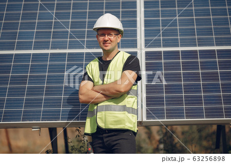 Man in a white helmet near a solar panel Man in a white helmet near a solar panel 63256898