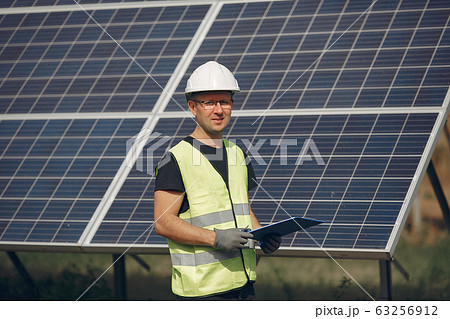 Man in a white helmet near a solar panel 63256912