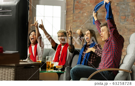 Excited group of people watching sport match, championship at home 63258728