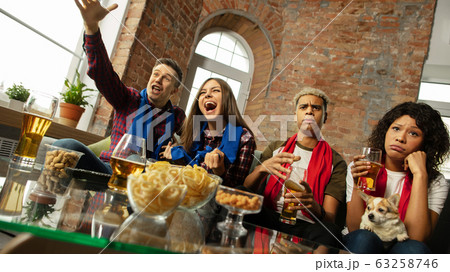 Excited group of people watching sport match, championship at home 63258746