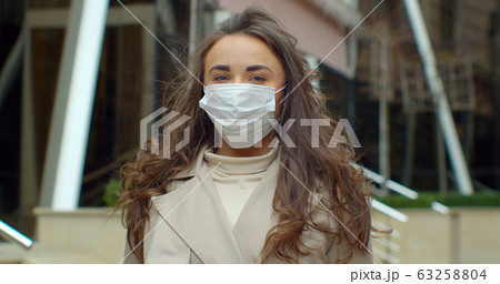 Portrait of a young student woman wearing protective mask on street.Concept of health and safety life, N1H1 coronavirus, virus protection. 63258804