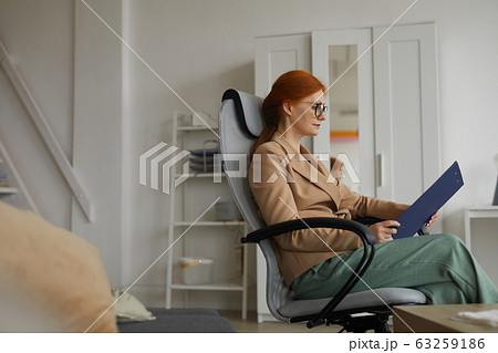 Businesswoman with document at office Businesswoman with document at office 63259186