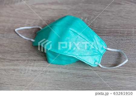 Protective face mask on wood table. 63261910