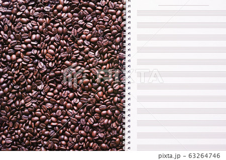 敷き詰めたコーヒー豆の上に開いた五線紙 63264746
