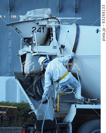 コンクリートミキサー車の洗浄をする運転手さんの写真素材