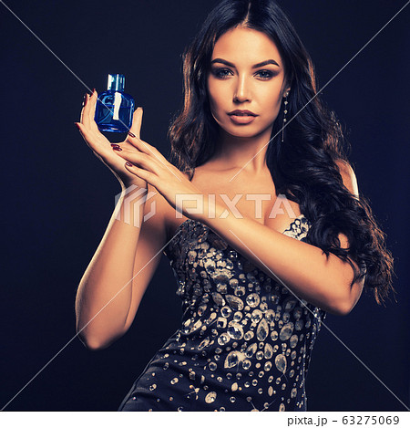 Beautiful young woman with bottle of perfume on 63275069