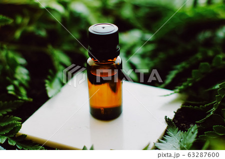 Bottle of herbal essential oil in a green tropical garden, natural scent and organic cosmetics Bottle of herbal essential oil in a green tropical garden, natural scent and organic cosmetics 63287600