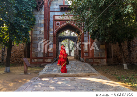 Indian woman in red sari near Arab Ki Sarai Indian woman in red sari near Arab Ki Sarai 63287910