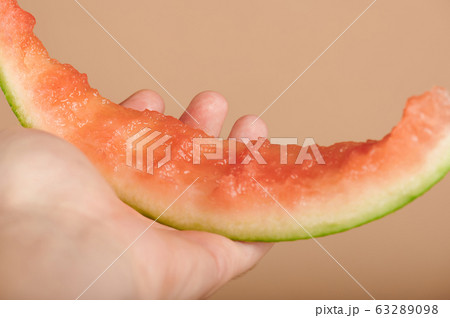 Hand holding eaten watermelon slice Hand holding eaten watermelon slice 63289098
