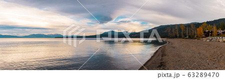 Panoramic sunset view of the shore, the dock and the hill full of pines in Lake Tahoe Panoramic sunset view of the shore, the dock and the hill full of pines in Lake Tahoe 63289470