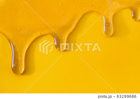 Flow of sweet honey on the yellow background with copy space Flow of sweet honey on the yellow background with copy space 63299686