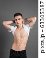 Sexy young man posing in studio. Gray background 63305387