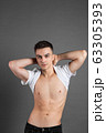 Sexy young man posing in studio. Gray background 63305393