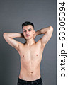 Sexy young man posing in studio. Gray background 63305394