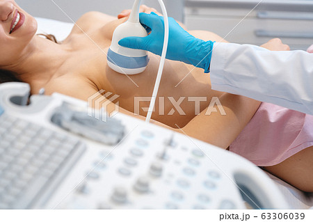 Woman patient having ultrasound scan to prevent breast cancer 63306039
