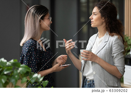 Smiling diverse colleagues chatting during coffee break in office 63309202