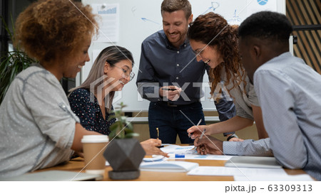 Happy diverse employees working with legal documents at meeting 63309313