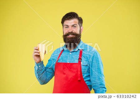 Cheese maker. Bearded man in apron hold piece Cheese maker. Bearded man in apron hold piece 63310242