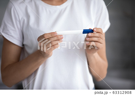 Cropped image young woman holding quick pregnancy test. Cropped image young woman holding quick pregnancy test. 63312908
